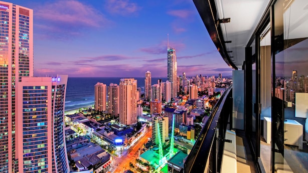Un hotel de altura con vista a la ciudad, incluyendo un rascacielos destacado y una playa.