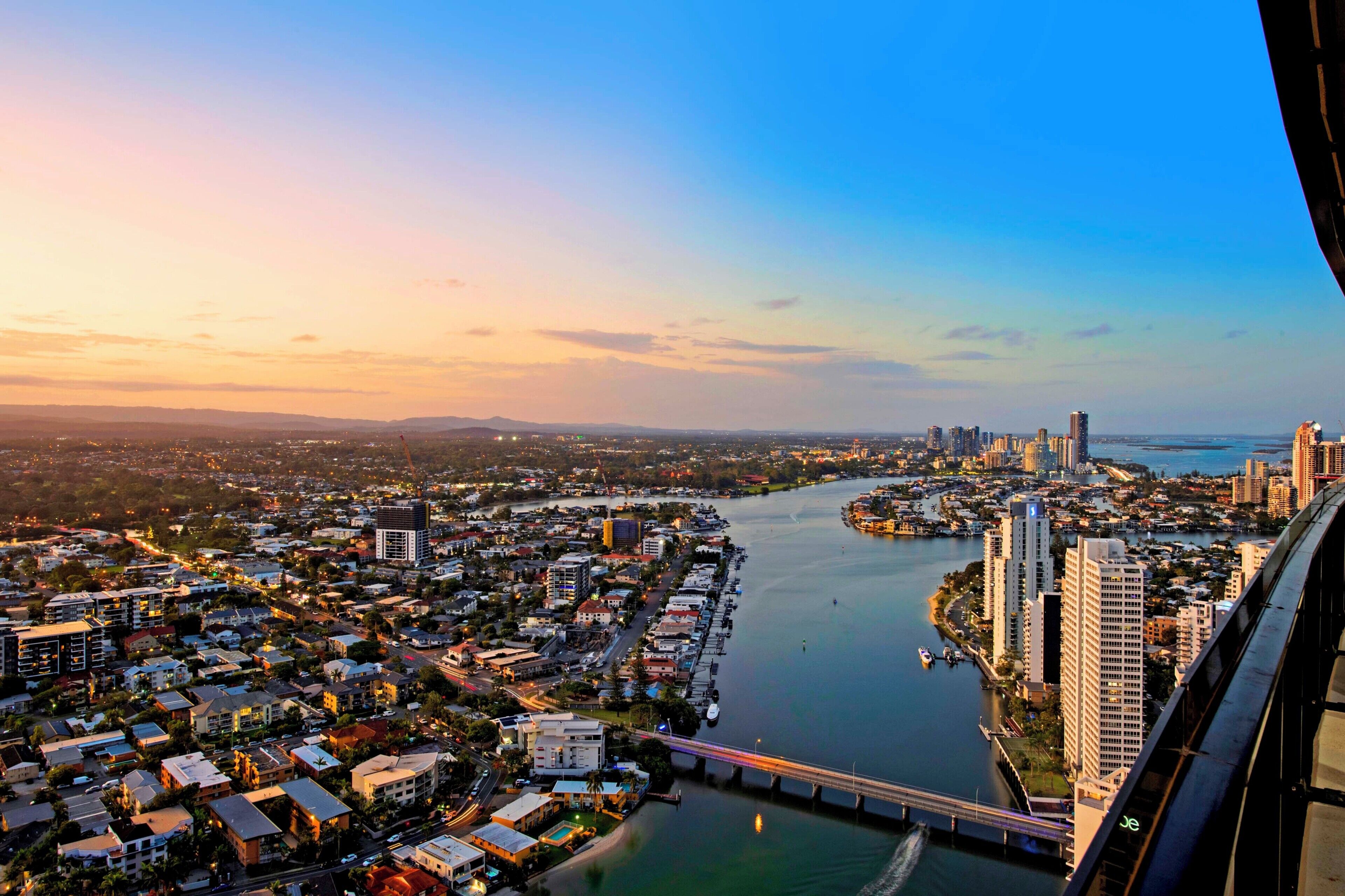 A cityscape with a river, high-rise buildings, and a bridge.