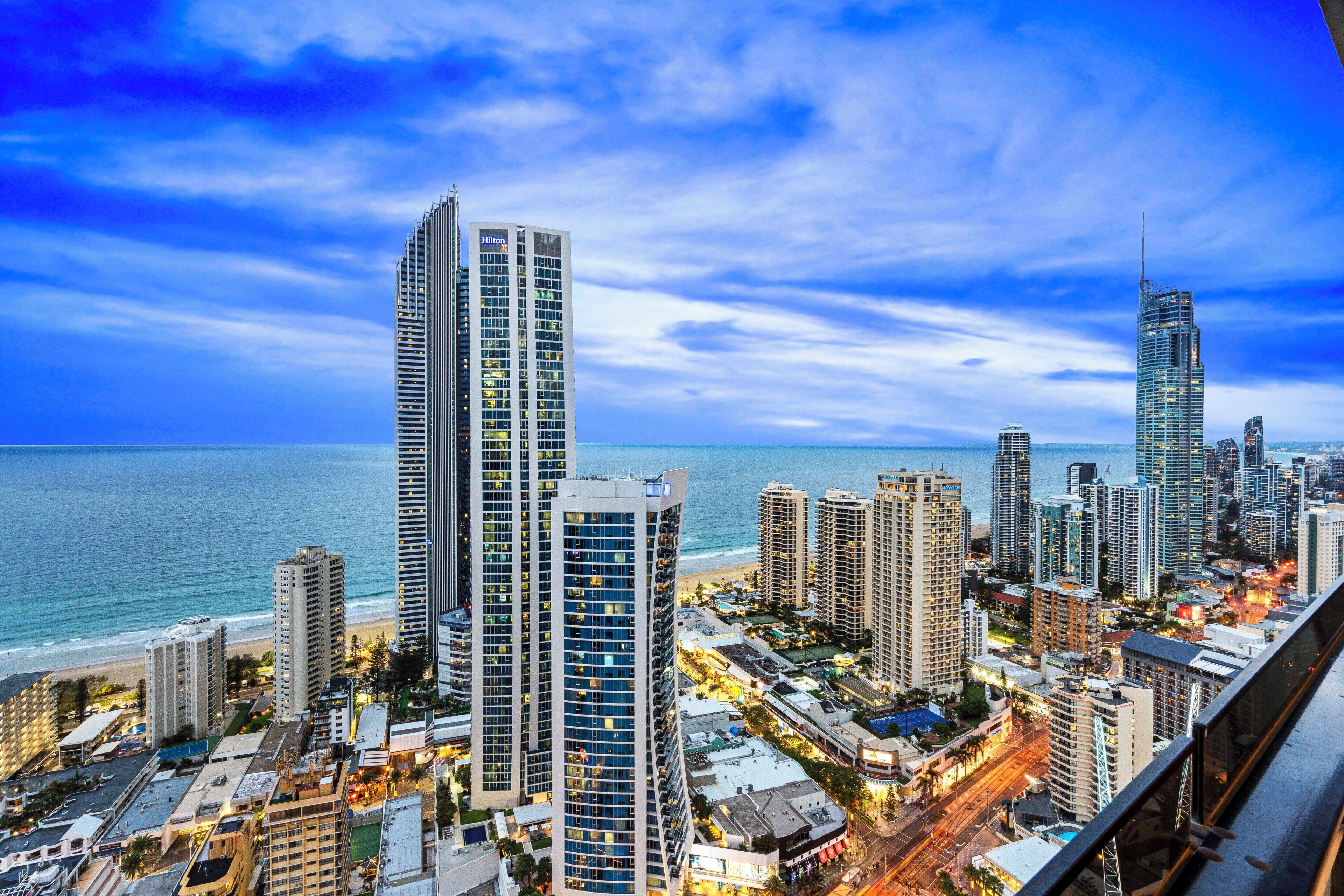 A cityscape with high-rise buildings, a beach, and a view of the ocean.