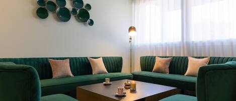 Una sala de estar moderna con un sofá verde, una mesa de centro de madera y un adorno en la pared.