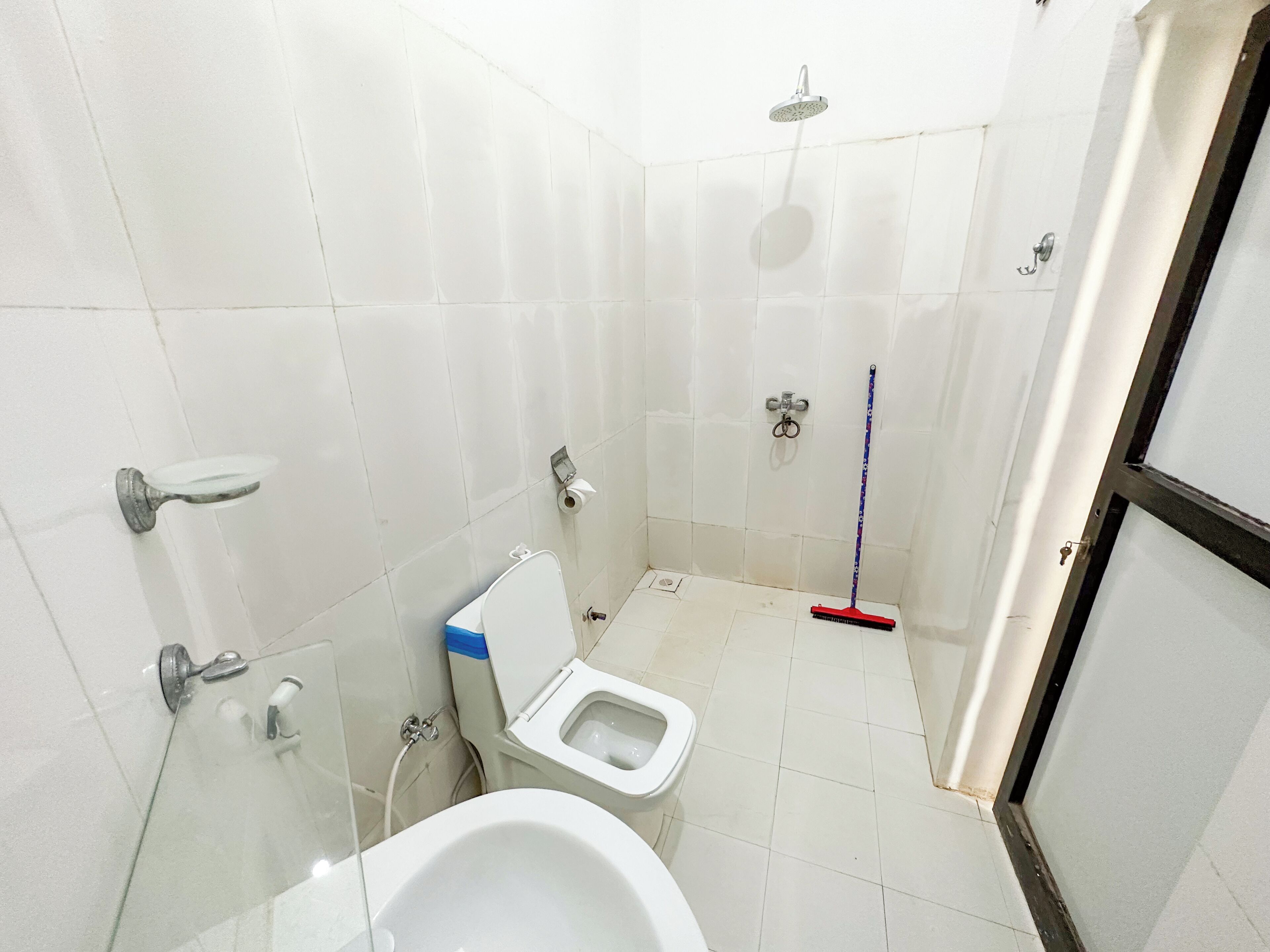 Et badeværelse med toilet, brusebad og bidet.