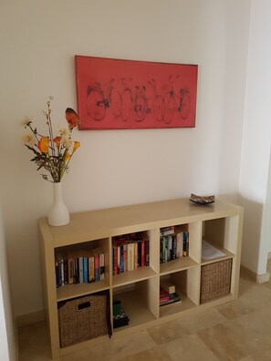 A bookshelf with books and a vase with flowers.