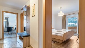 Une chambre d’hôtel avec un lit, un bureau, une chaise et une vue sur un paysage enneigé.