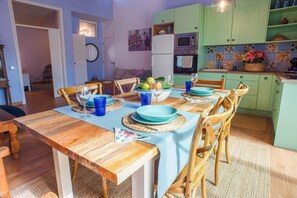 Un coin repas avec une table en bois, des chaises et une cuisine en arrière-plan.