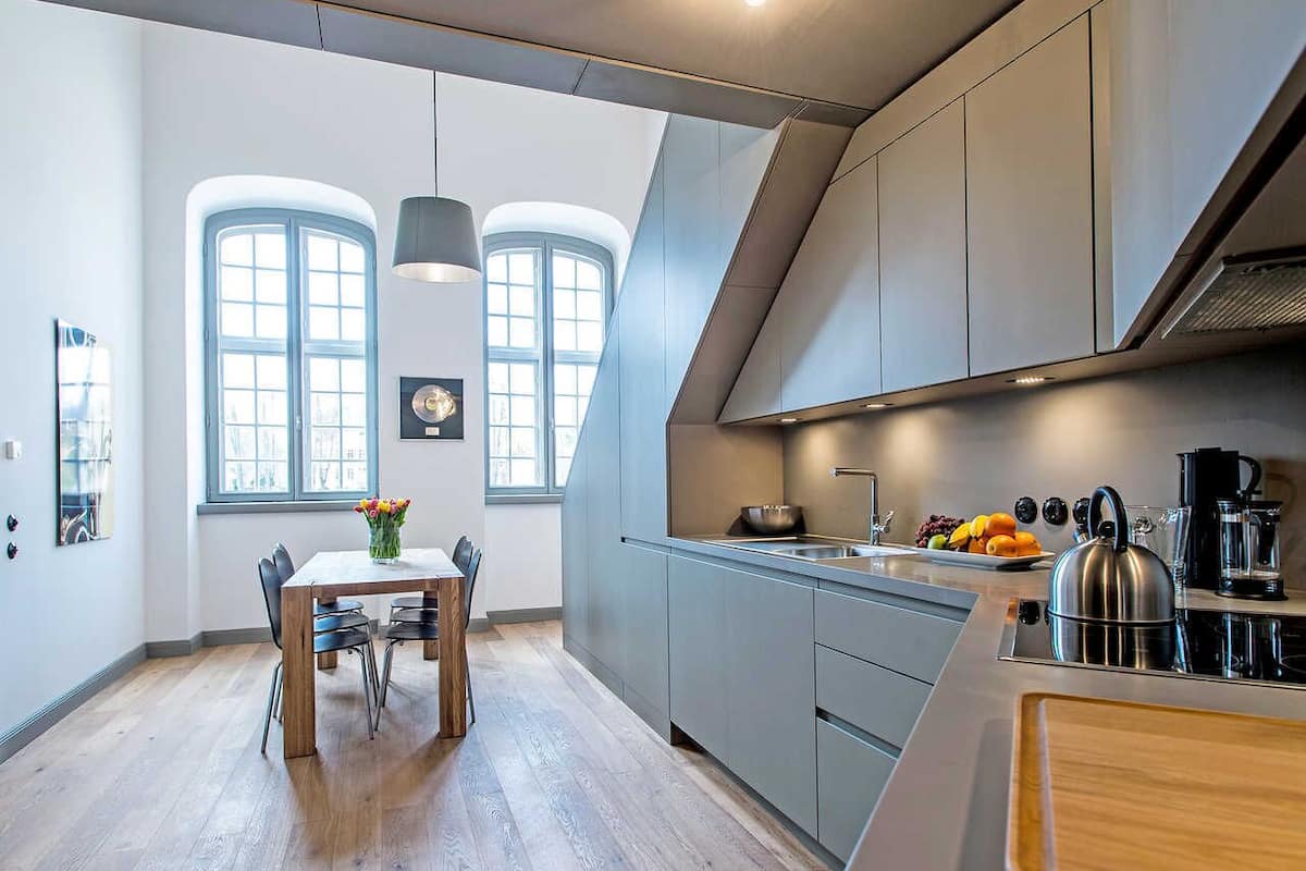 Une cuisine moderne avec un coin repas, de grandes fenêtres et une vue sur la ville.