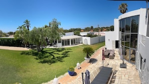 A modern house with a swimming pool, a well-maintained lawn, and a patio area with outdoor furniture. - PRIVATE VILLA WITH POOL IN THE ALGARVE AT OLHAO NEAR FARO (OLHAO)
