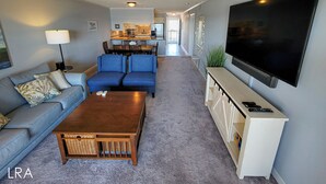 A living room with a sofa, a coffee table, a TV, and a ceiling fan.