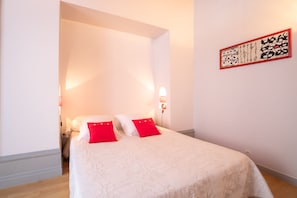 A neatly arranged bedroom with a bed, pillows, and a wall-mounted artwork. - BSH - Beaune Rousseau - Parking included (Beaune)