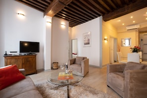 A modern living room with a glass coffee table, sofas, a TV, and a wooden cabinet. - BSH - Beaune Rousseau - Parking included (Beaune)