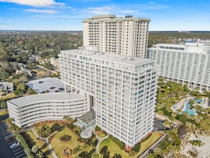 A high-rise hotel with multiple floors, a central courtyard, and a swimming pool.