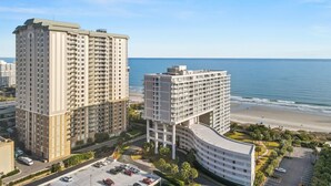 Ein hoch aufragendes Hotel mit mehreren Etagen, einer geschwungenen Struktur und Blick auf den Strand.