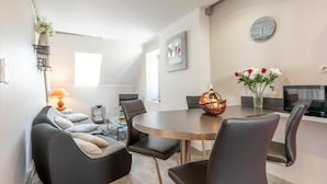 A modern dining area with a round table, black chairs, and a vase with flowers. - BSH - Beaune Saint Etienne - Parking included (Beaune)