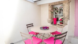A small patio with a round table and four chairs, a window with flowers, and a door. - BSH - Beaune Saint Etienne - Parking included (Beaune)