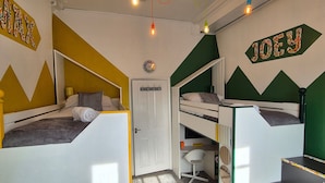 A dormitory room with bunk beds, a desk, and a chair. There are string lights hanging from the ceiling. - Spacious 2 Bed/Bath Central Apt, Parking & Garden (Exeter)