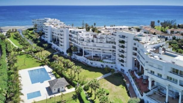 Un hotel de varios pisos con piscina y vista al mar.