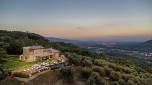 Une villa en pierre dotée d’une piscine, entourée d’une végétation luxuriante et offrant une vue imprenable sur la campagne environnante.