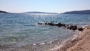 On peut clairement voir une plage avec une eau calme et un rivage rocheux.