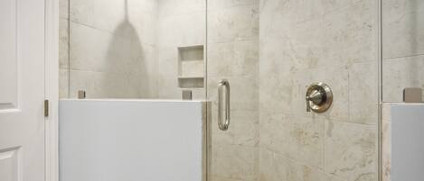 Un baño moderno con ducha, inodoro y lavamanos.