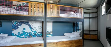 A bunk bed room with a wooden floor, a ceiling light, and a wall mural.