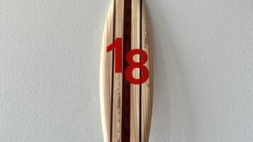 A wooden surfboard with the number 18 on it.