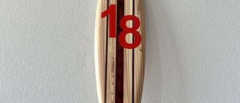 A wooden surfboard with the number 18 on it.