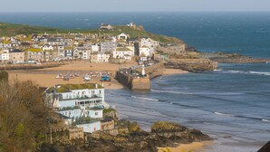 A coastal town with a prominent sea wall, a lighthouse, and a mix of residential and commercial buildings.