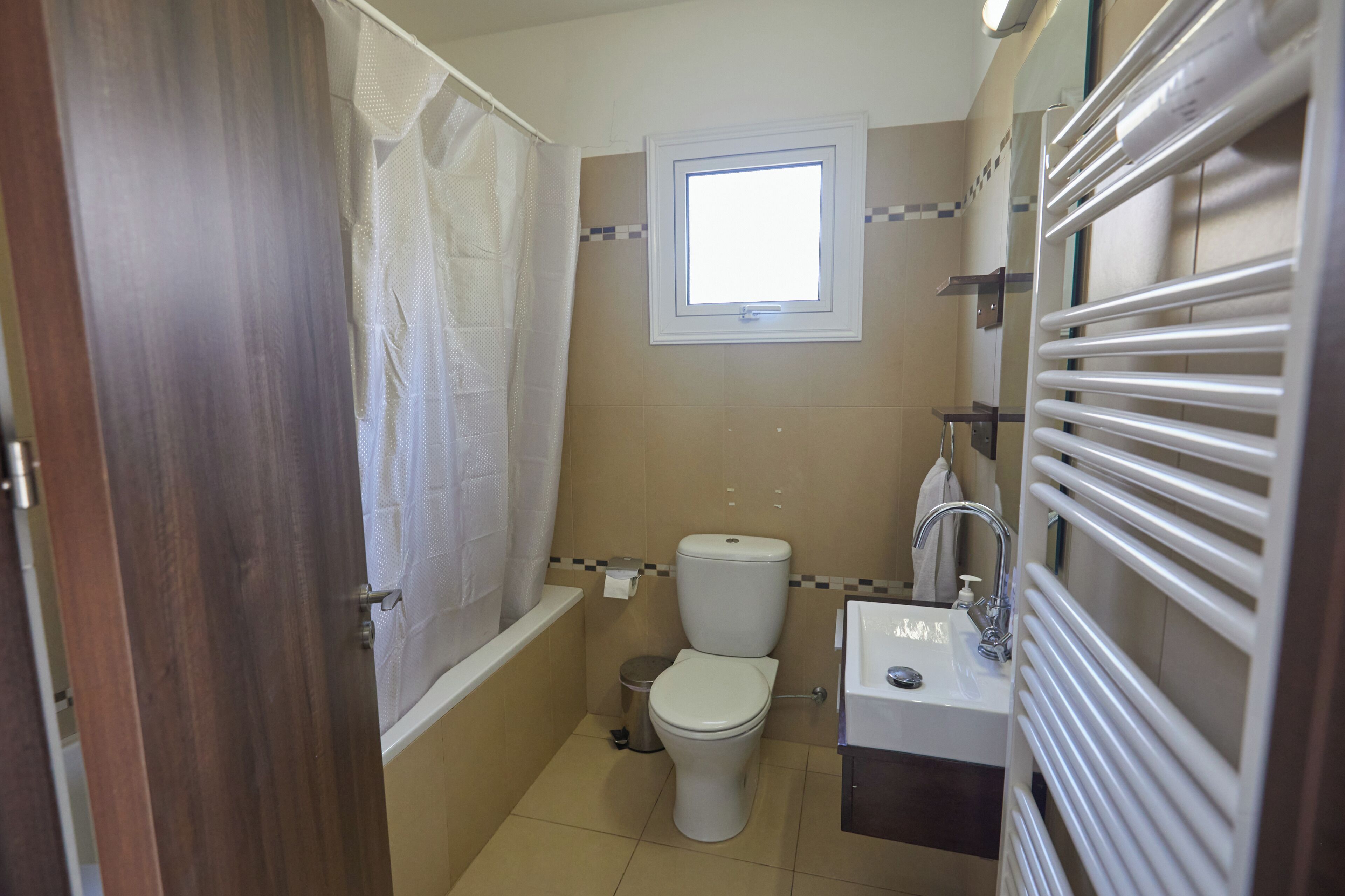 A bathroom with a toilet, sink, and shower.
