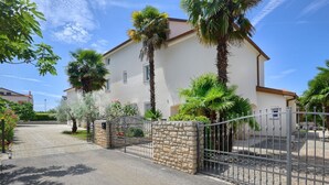 Una casa a due piani con un cancello in pietra e un vialetto lastricato.