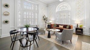 A spacious living room with a round dining table, dark wooden chairs, a brown sofa, and a coffee table. - Kasa Capitol Hill Downtown Nashville (Nashville)