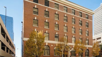 A multi-story brick building with a symmetrical facade, large windows, and a central entrance with a decorative arch.