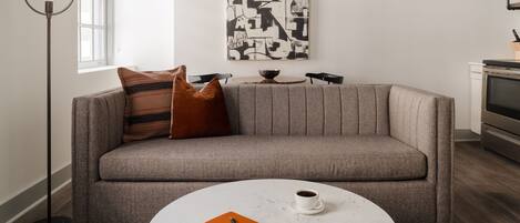 A modern living room with a grey sofa, a round coffee table, and a floor lamp.