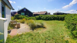Un quartiere residenziale con case, un giardino erboso e un vialetto lastricato.