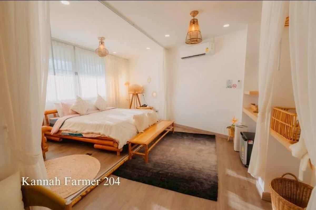 A cozy bedroom with a bed, bedside table, and a small seating area.