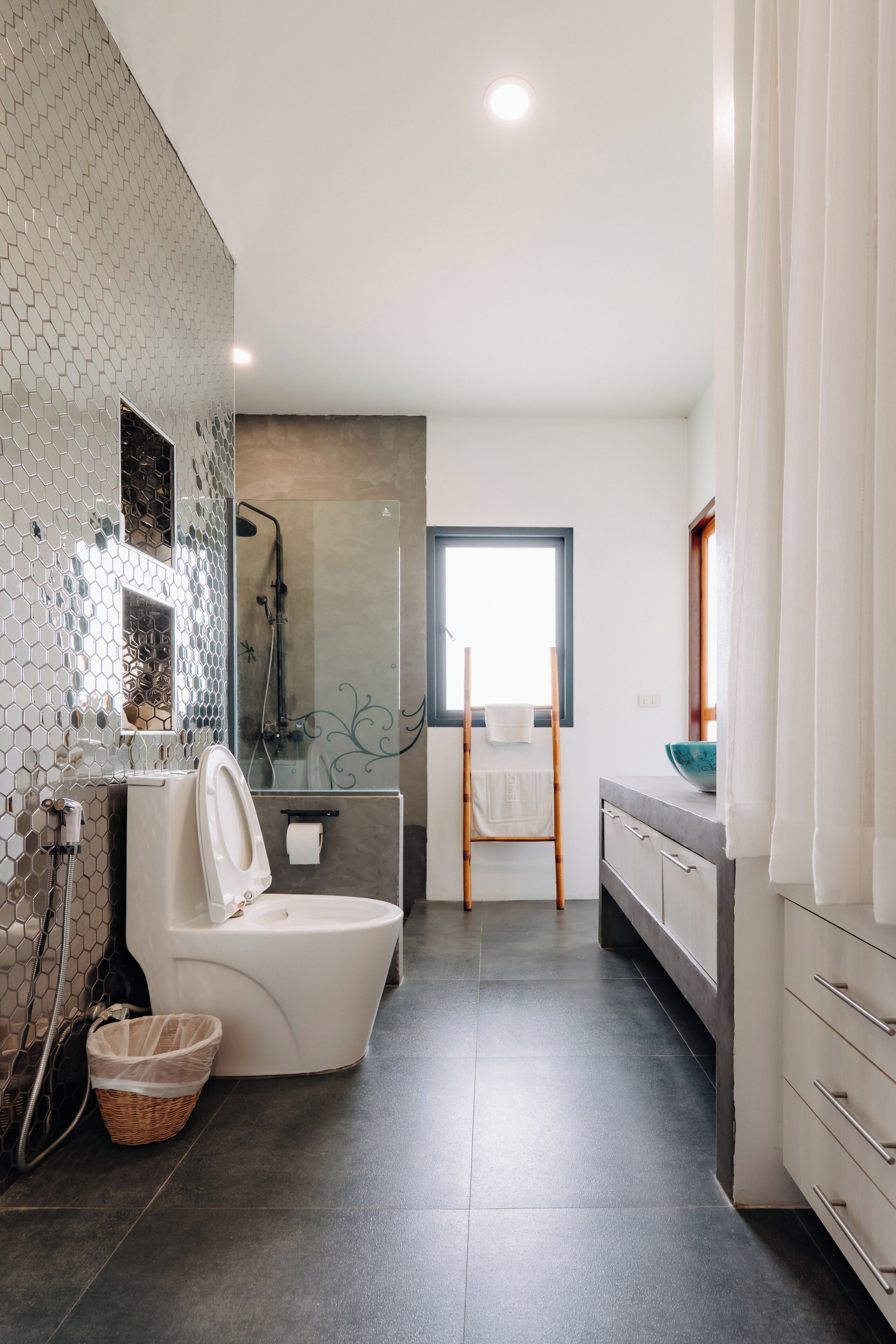 A modern bathroom with a toilet, shower, and sink.