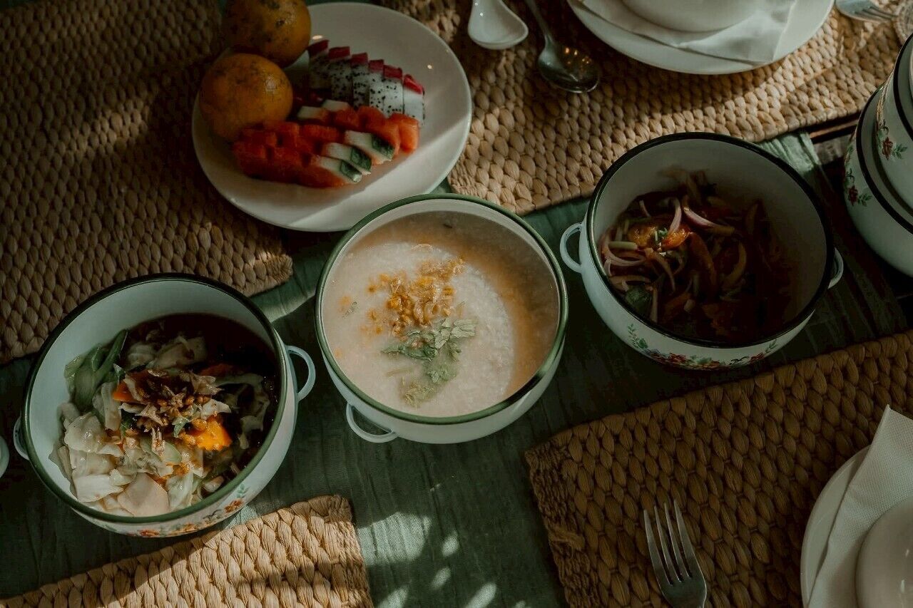 Une table garnie de différents plats, notamment un bol de soupe, une assiette de fruits et un saladier.