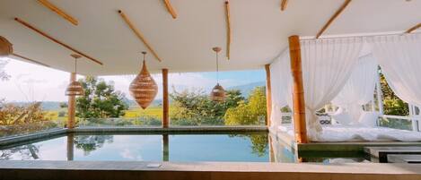 Un área de piscina tranquila con vistas a exuberante vegetación y montañas.