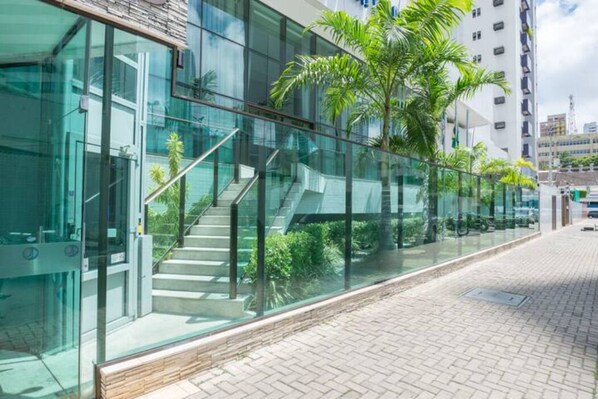 A modern building with glass walls, a staircase, and a paved walkway.