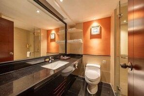 A modern bathroom with a large mirror, a sink, a toilet, and a glass shower enclosure. - Dron Hotel (Dongguan)