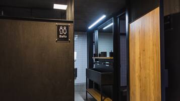 Men's facilities with a wooden panel and metal sink area.