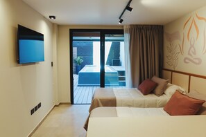 A hotel room with a bed, a flat-screen TV, a sliding glass door leading to an outdoor area, and a ceiling light fixture. - FAZ HOSTEL BOUTIQUE (Córdoba)
