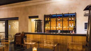 A bar area with wooden furniture and a brick wall backdrop.
