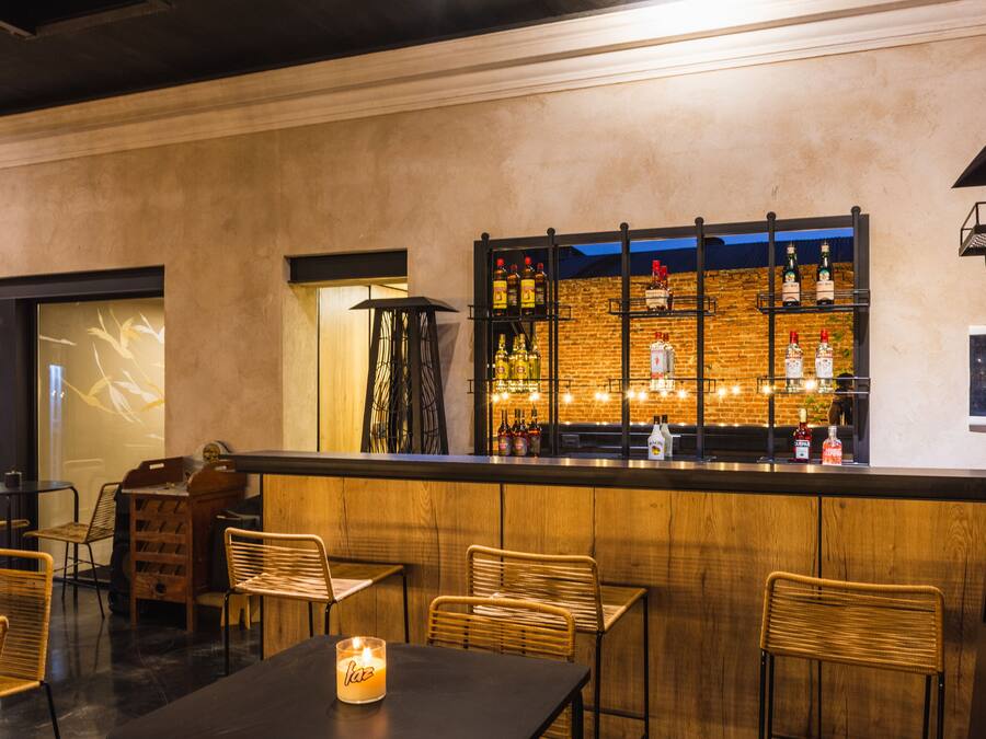 A bar area with wooden furniture and a brick wall backdrop.