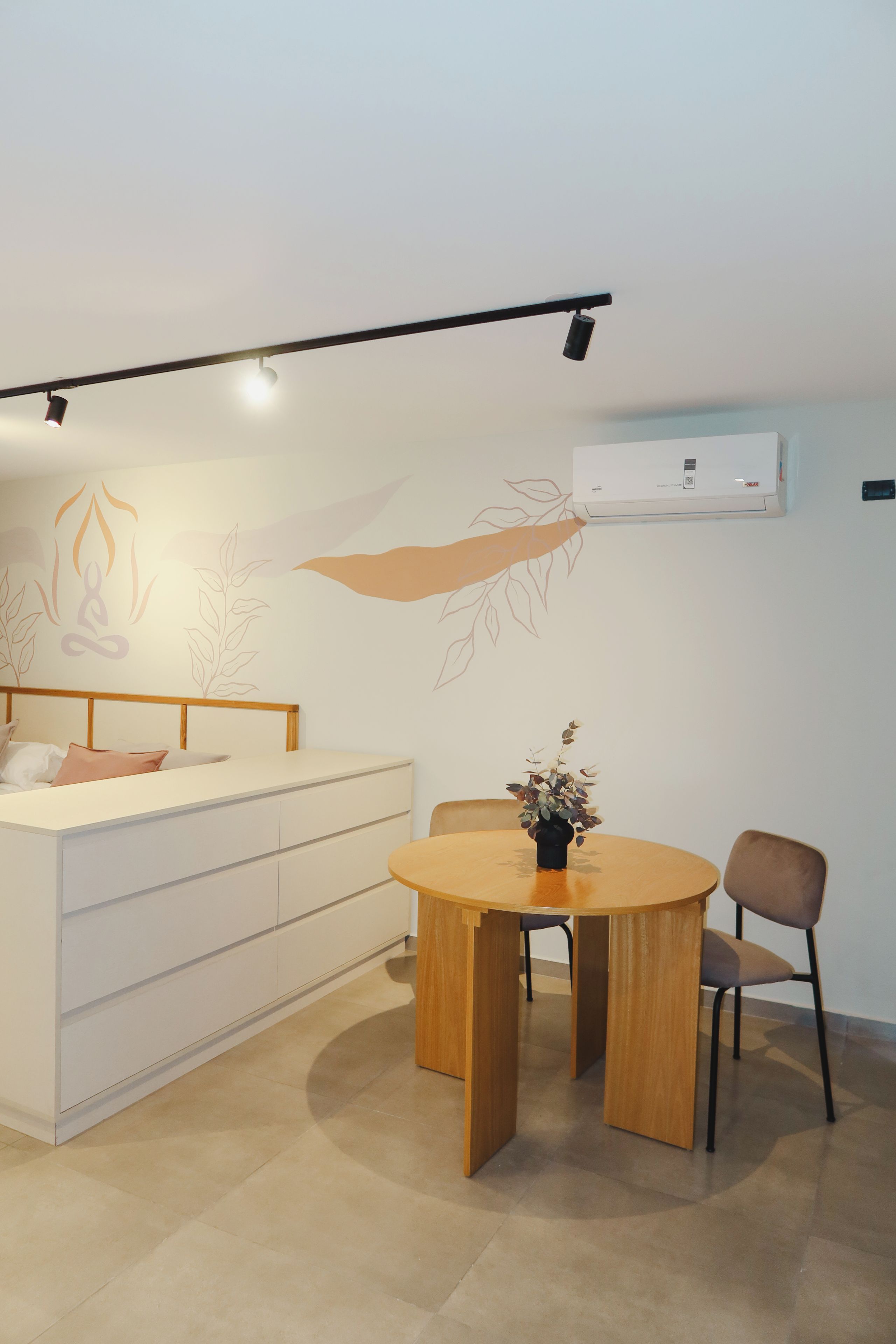 A modern bedroom with a bed, bedside table, and a small round table with a chair.