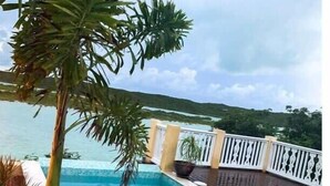 A swimming pool with a view of the sea and a white fence. - Chalk Sound Waterfront Cottage: Pool & Kayak (Providenciales)