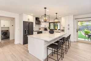 A modern kitchen with a central island, built-in appliances, and a view to a backyard. - Modern Oasis|2 Primarys|Pool, Spa & Putting Green (Scottsdale)