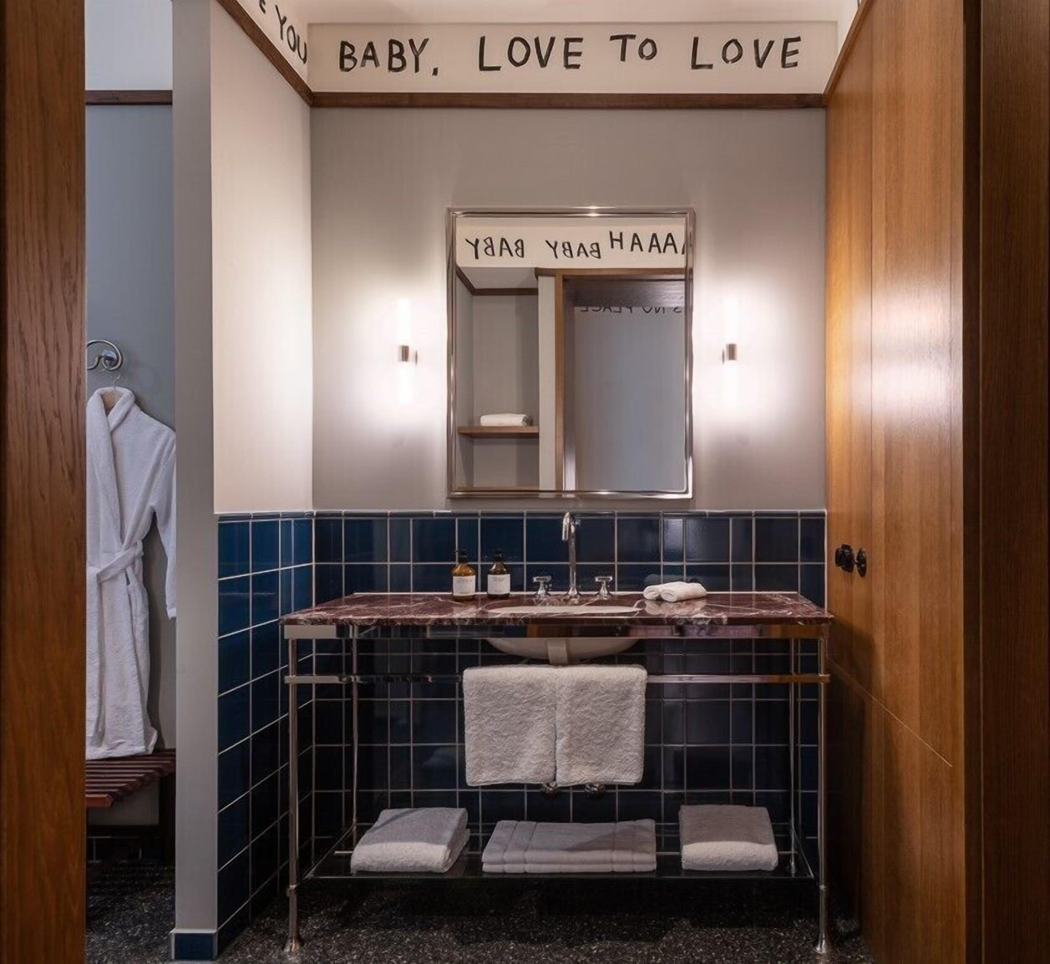 Un baño con tocador, espejo y toallero.