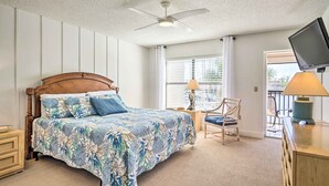 A bedroom with a bed, a ceiling fan, a TV, a chair, and a window with blinds. - NEW NEW   Burnt Store Marina Front,  Premier Corner Unit, 30-Day Minimum Retreat (Punta Gorda)