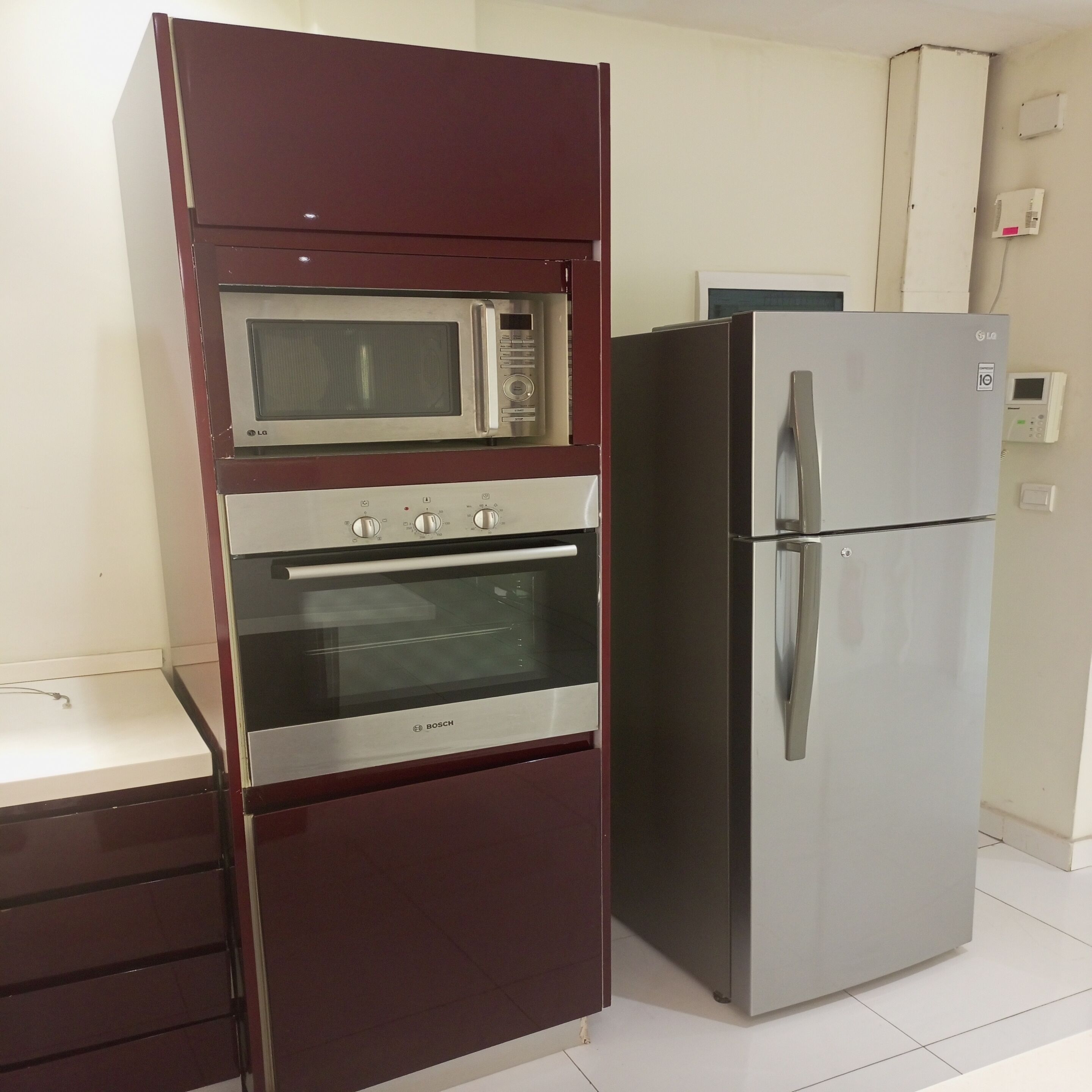 A kitchen with a built-in microwave, oven, and refrigerator.