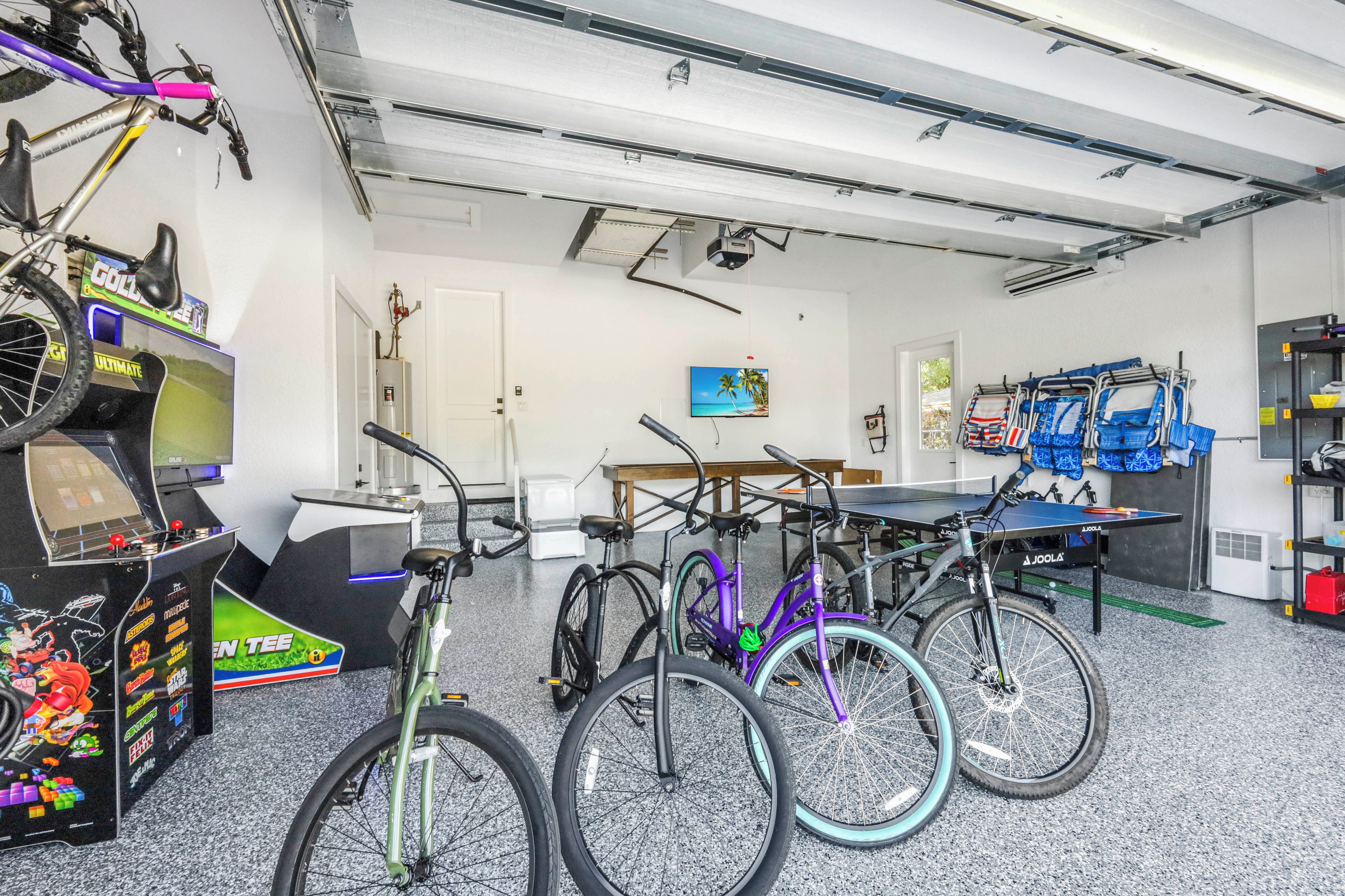 Een kamer met fietsen, een tafeltennistafel en speelautomaten.