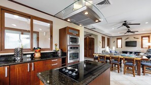 Una cocina moderna con encimeras de granito, electrodomésticos de acero inoxidable y armarios de madera.
